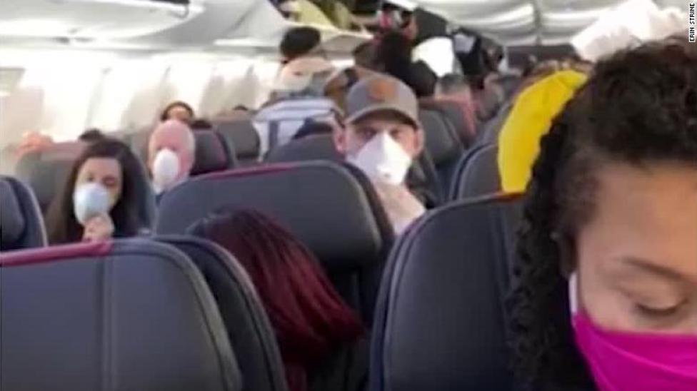 Pasażerowie z maskami na pokłądzie samolotu, fot. CNN