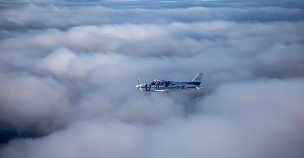 Samolot w locie nad chmurami - widok z boku (fot. Ośrodek Szkolenia Lotniczego)