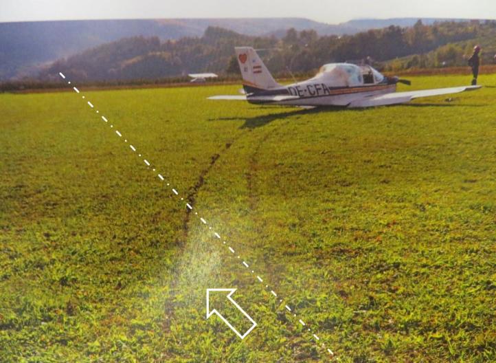 Ślady samolotu Tecnam T2002 JR na dobiegu. Białą linią i strzałką pokazano właściwy kierunek lądowania (oś RWY 22) (fot. Policja)
