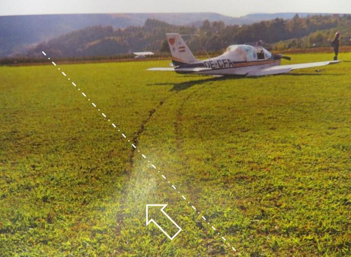Ślady samolotu Tecnam T2002 JR na dobiegu. Białą linią i strzałką pokazano właściwy kierunek lądowania (oś RWY 22) (fot. Policja)