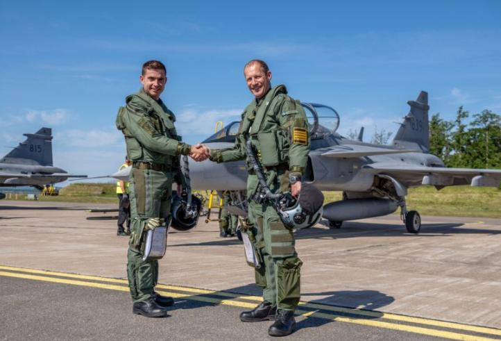 Piloci - szwedzki i brazylijski - podają sobie ręce przed myśliwcami Gripen (fot. SAAB)
