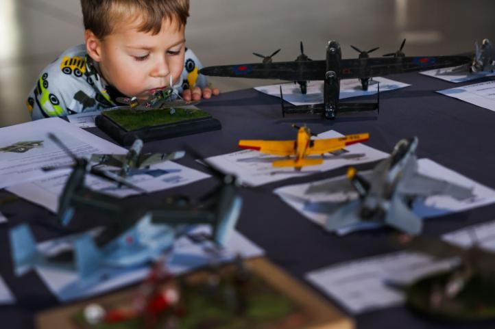 Mały chłopiec przygląda się modelom samolotów na wystawie w Muzeum Lotnictwa Polskiego (fot. Muzeum Lotnictwa Polskiego)