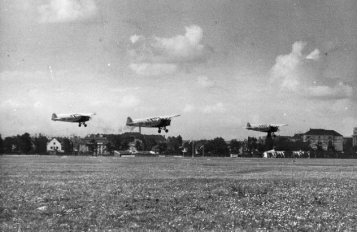 Samoloty na lotnisku mokotowskim w Warszawie podczas zawodów lotniczych. Klucz samolotów RWD-8 (fot. Narodowe Archiwum Cyfrowe)