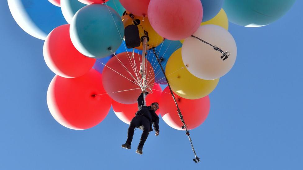 Dawid Blaine podwieszony pod balony w helem, fot. national-geographic