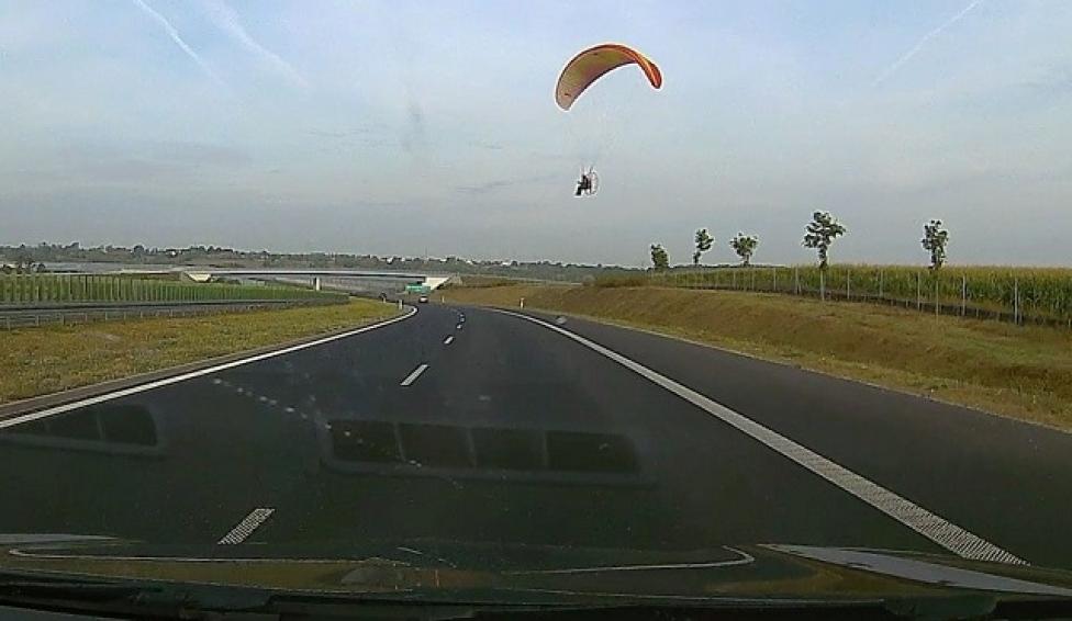 Motoparalotniarz podczas niskiego przelotu nad drogą, fot. PSP