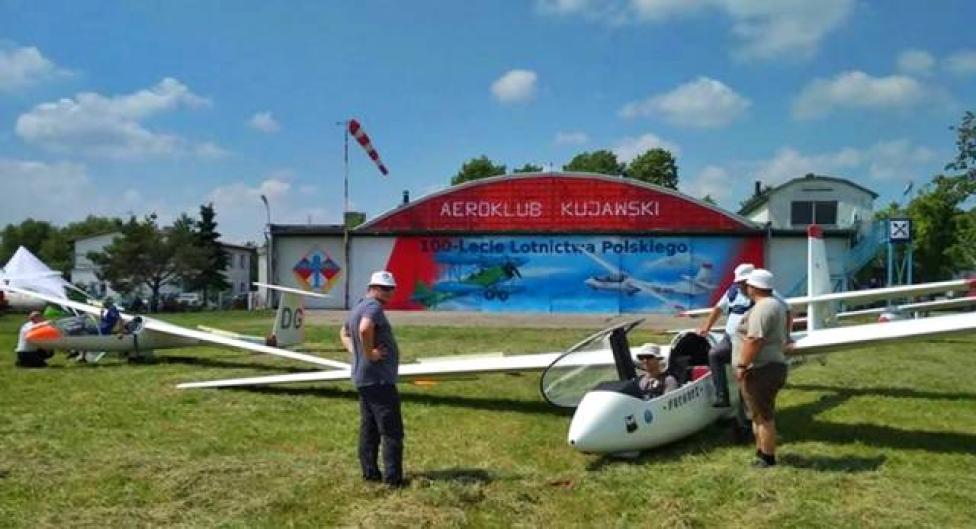 Szybowce przed hangarem Aeroklubu Kujawskiego - mural na 100-lecie Lotnictwa Polskiego w tle (fot. Aeroklub Kujawski/FB)