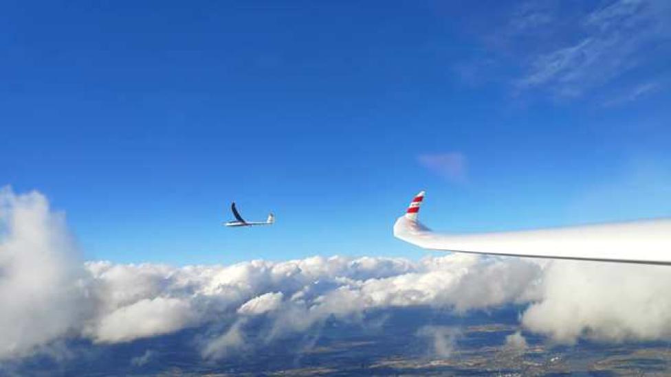 Szybowiec w locie nad chmurami - skrzydło drugiego szybowca (fot. Gliding Team Klinika Kolasiński)