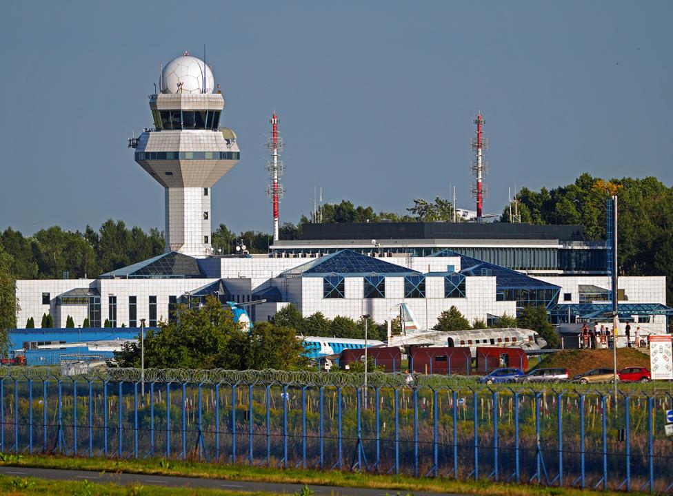 Wieża kontroli lotów na Lotnisku Chopina - widok zza ogrodzenia (fot. Piotr Bożyk/PAŻP)