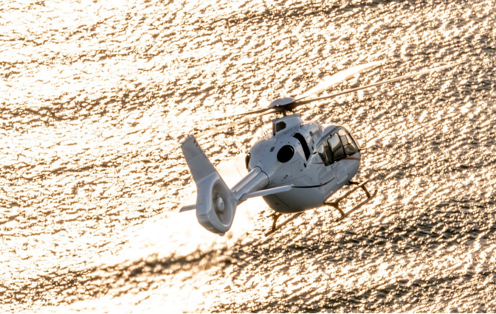 H135 w locie nad wodą - widok z tyłu (fot. Airbus Helicopters)
