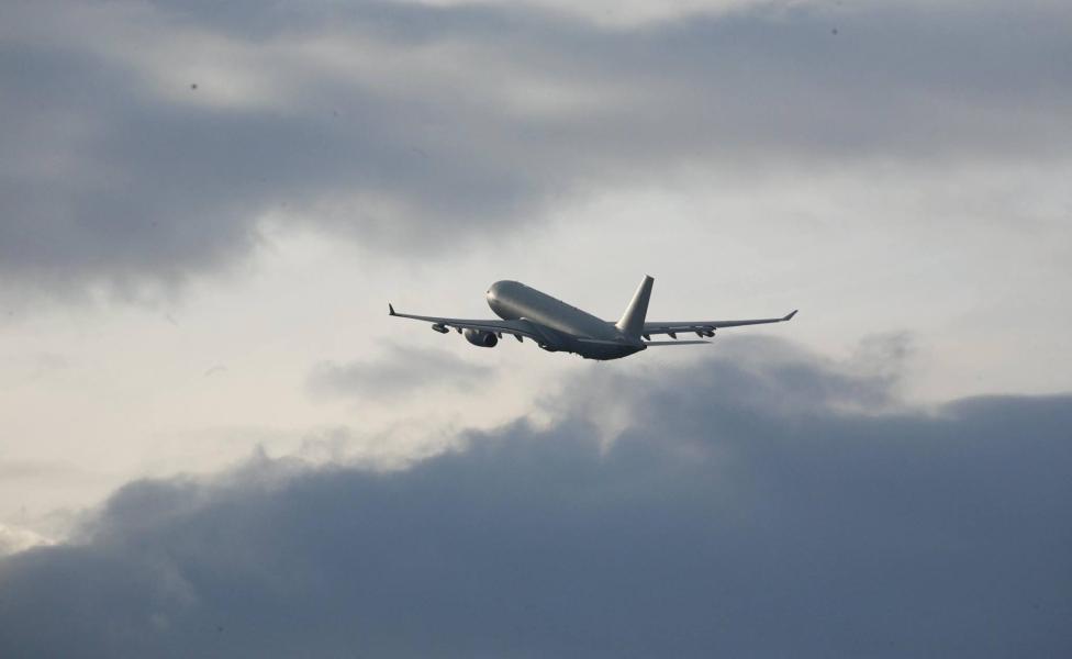 Samolot pasażerski w locie na tle pochmurnego nieba - widok z tyłu (fot. Ministerstwo Infrastruktury)
