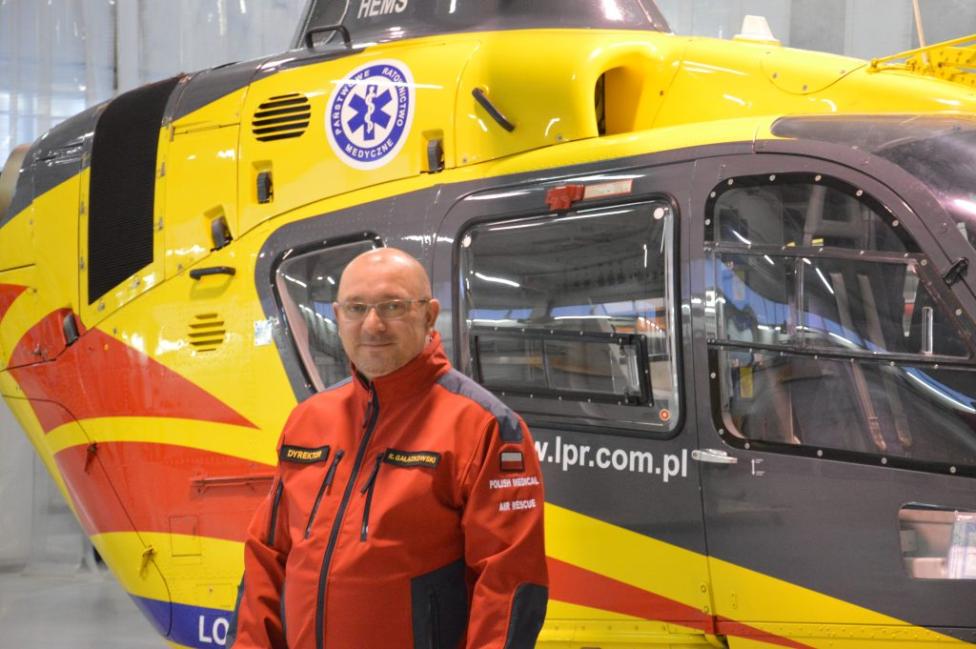 Robert Gałązkowski przed śmigłowcem EC135 Lotniczego Pogotowia Ratunkowego (fot. LPR)