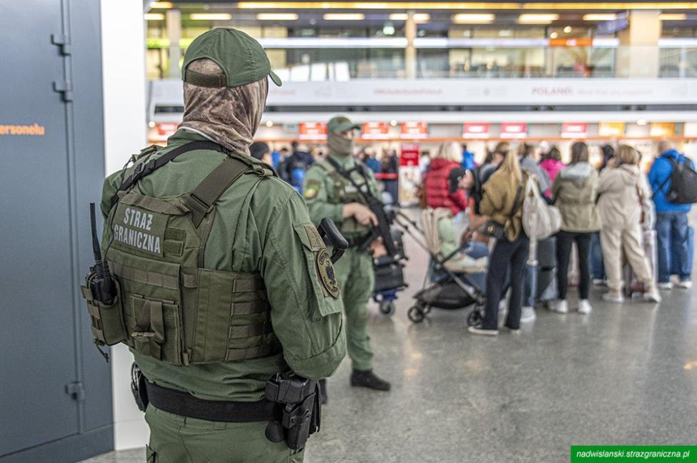 Funkcjonariusze Grupy Interwencji Specjalnych stoją w terminalu Lotnisku Chopina (fot. Nadwiślański OSG)