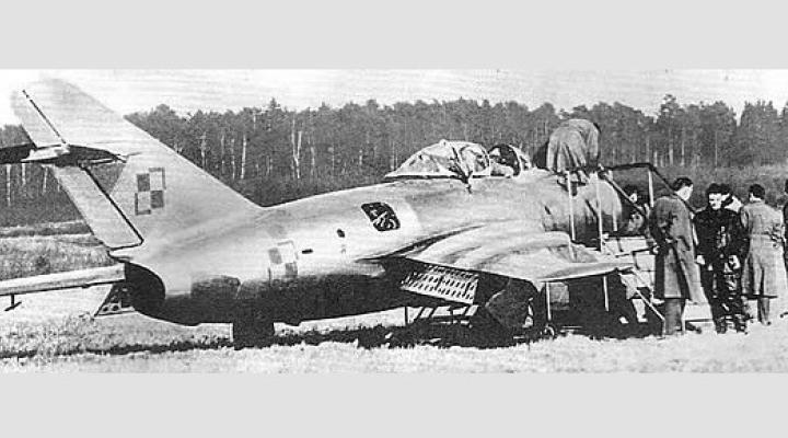 Franciszek Jarecki w ciemnym kombinezonie i MiG-15bis krótko po wylądowaniu na duńskiej wyspie Bornholm (fot. jareckivalves.net)