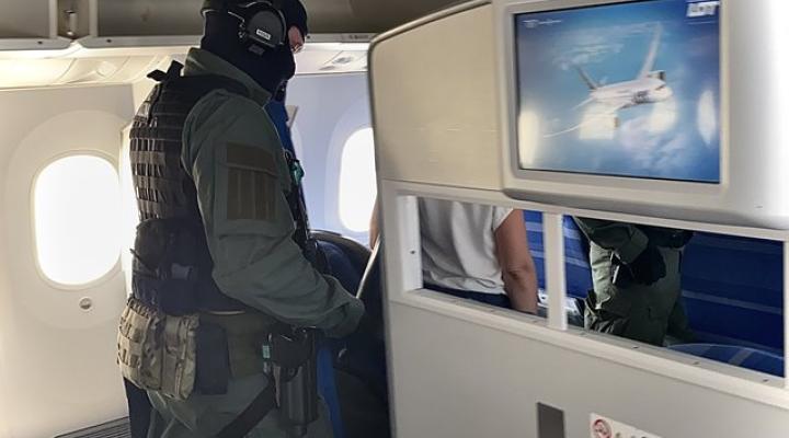 Funkcjonariusz GIS wyprowadza z pokładu samolotu pasażera (fot. nadwislanski.strazgraniczna.pl)