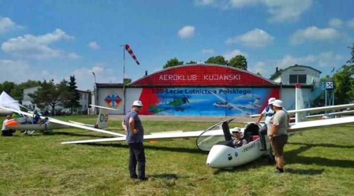 Szybowce przed hangarem Aeroklubu Kujawskiego - mural na 100-lecie Lotnictwa Polskiego w tle (fot. Aeroklub Kujawski/FB)