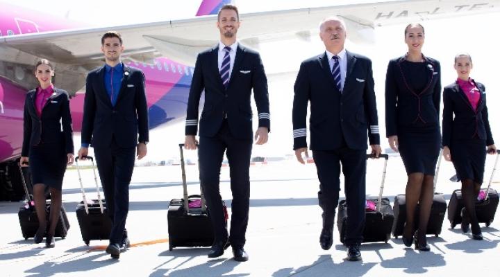 Załoga Wizz Air na płycie lotniska przed skrzydłem samolotu (fot. Wizz Air)