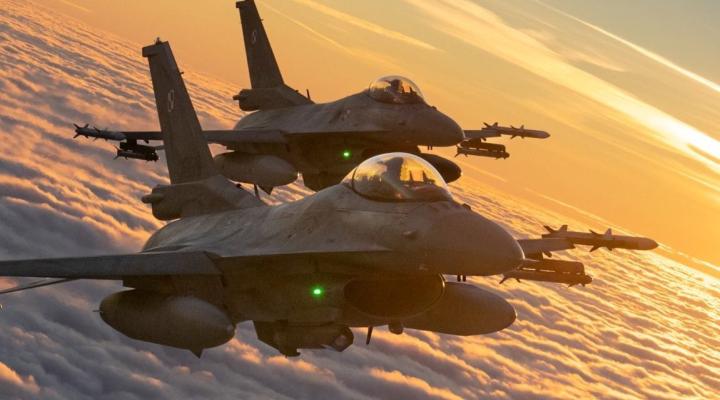 Dwa samoloty F-16 Polskich Sił Powietrznych w locie nad chmurami o zachodzie słońca - widok z ukosa (fot. Sztab Generalny WP/Facebook)