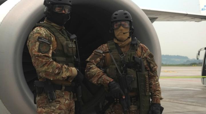 Funkcjonariusze Zespołu Interwencji Specjalnych przez silnikiem samolotu na lotnisku w Krakowie (Karpacki OSG)