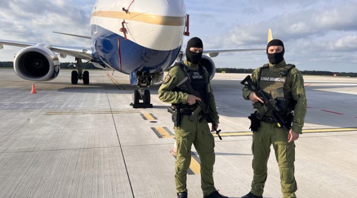 Funkcjonariusze Zespołu Interwencji Specjalnych na płycie lotniska w Katowicach przed samolotem (fot. Śląski OSG)