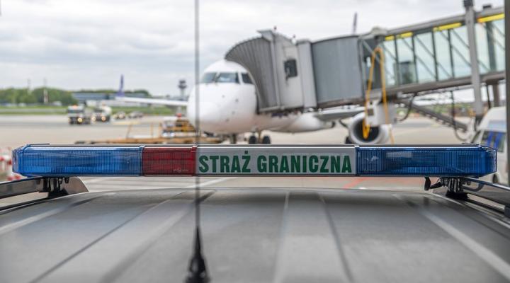 Samochód Straży Granicznej przed samolotem przy rękawie na płycie Lotniska Chopina (fot. Nadwiślański OSG)