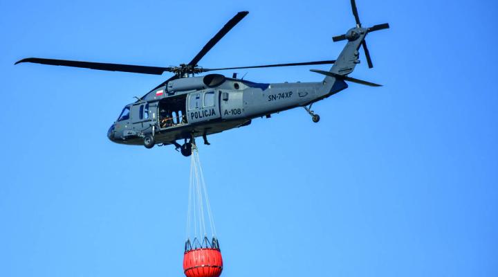 Policyjny Black Hawk z podwieszonym zbiornikiem bambi bucket w locie (fot. sierż. Konrad Karwacki, KWP w Białymstoku)