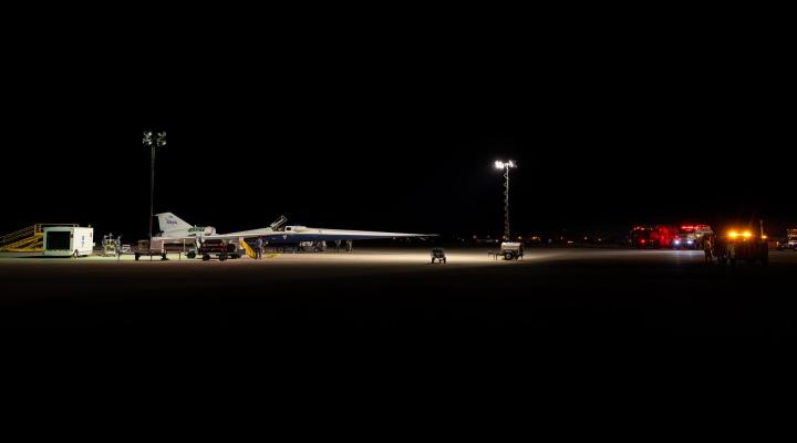 X-59 - maddźwiękowy samolot badawczy NASA widziany o świcie w otoczeniu wozów strażackich i personelu bezpieczeństwa (fot. Lockheed Martin)