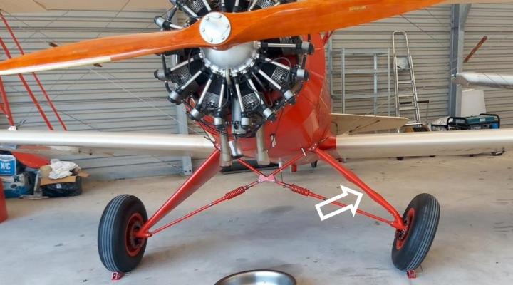 Samolot Hatz Classic ze zdeformowaną golenią podwozia. Strzałką pokazano miejsce uszkodzenia (fot. użytkownik samolotu, z raportu PKBWL)