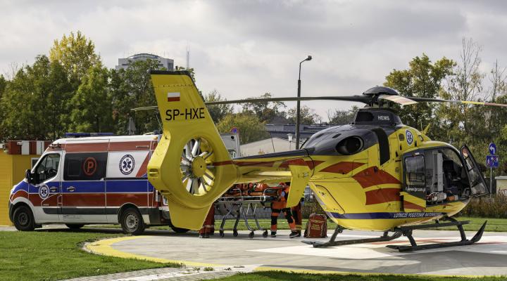 EC135 Lotniczego Pogotowia Ratunkowego na lądowisku, karetka obok (fot. Piotr Kostuś)