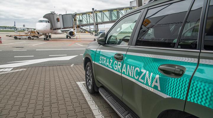 Samolot pasażerski przy rękawie i samochód Straży Granicznej na płycie lotniska (fot. Nadwiślański OSG)