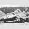 Franciszek Jarecki w ciemnym kombinezonie i MiG-15bis krótko po wylądowaniu na duńskiej wyspie Bornholm (fot. jareckivalves.net)