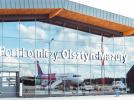 Port Lotniczy Olsztyn-Mazury - napis na termnalu i odbicie samolotu w szybie (fot. Port Lotniczy Olsztyn-Mazury)