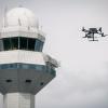 Dron w locie - wieża kontroli lotów na Lotnisku Chopina w tle (fot. PAŻP)
