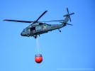 Policyjny Black Hawk z podwieszonym zbiornikiem bambi bucket w locie (fot. sierż. Konrad Karwacki, KWP w Białymstoku)